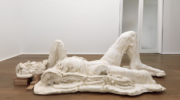 Modern, partially abstract sculpture of a person laying on the floor